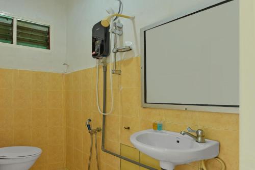 y baño con ducha, lavabo y aseo. en OYO 90744 Bari Indah Beach Resort, en Kuala Terengganu