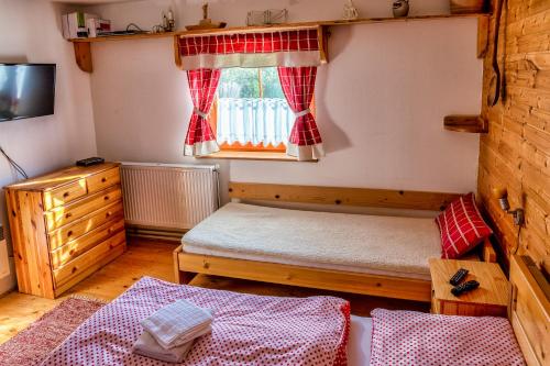 a small room with a bed and a window at Chalupa u Žofky in Oščadnica