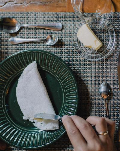 a person cutting a piece of cake on a green plate at LA PIANTA - Uma experiência na Villa de Monte Verde in Monte Verde