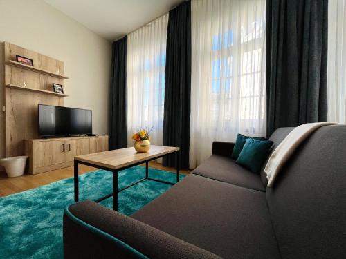 ein Wohnzimmer mit einem Sofa und einem TV in der Unterkunft Gemütliches Apartment mit Blick zur Frauenkirche in Dresden