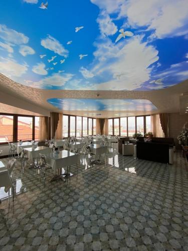 a dining room with tables and a ceiling with a sky at OTEL KING in Isparta