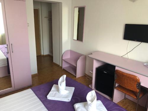 een kamer met een bed en een tafel met twee witte tissues bij Hotel Parc in Alexandria