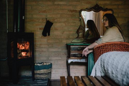 a woman sitting in a chair in front of a mirror at LA PIANTA - Uma experiência na Villa de Monte Verde in Monte Verde