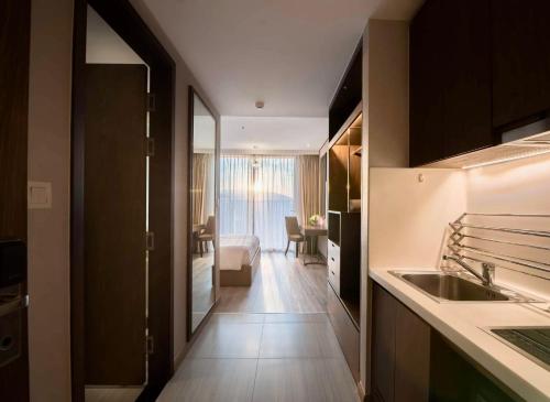 a kitchen with a sink and a living room at Panorama Nha Trang Inn in Nha Trang
