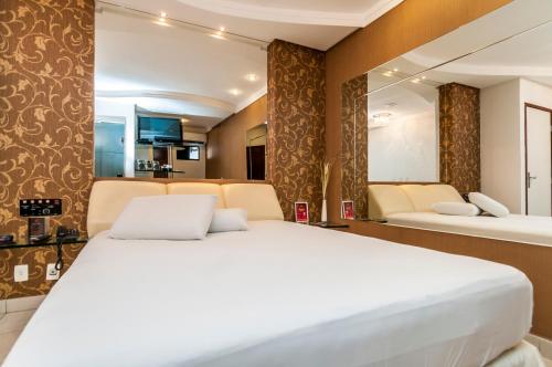 a bedroom with a large white bed in a room at Trópicos Motel in Natal