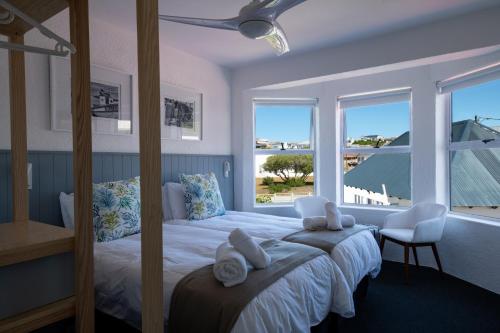 a bedroom with a large bed with towels on it at Cape Agulhas Guest House in Agulhas