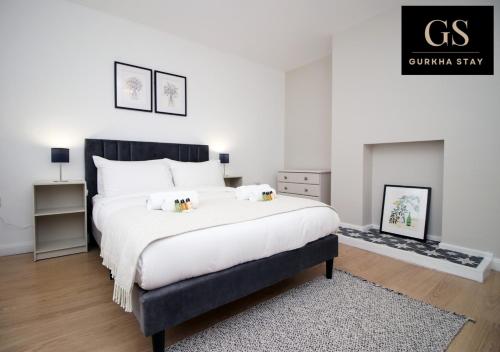 um quarto com uma cama grande e uma lareira em 4 Bedroom Modern House, Perfect for Int-Students, Family Relocations, Groups & Contractors by Gurkha Stay Cardiff With Off-Road Parking & WiFi em Cardiff