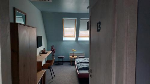a room with a bed and a table and a window at Bornemisza Kúria Wellness Resort in Tiszabecs