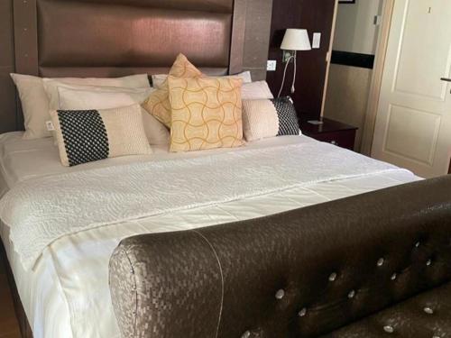 a large bed with white sheets and pillows at Le Chef BnB in Mthatha