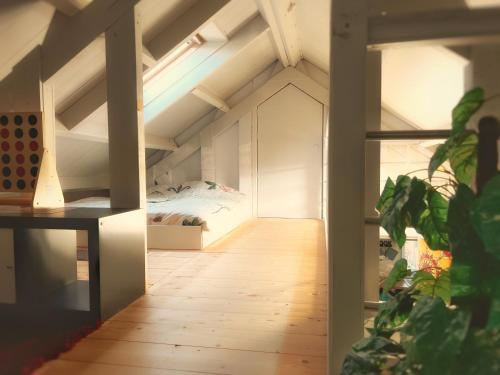 an attic room with a bed and a wooden floor at Het Wierhuis in Pieterburen