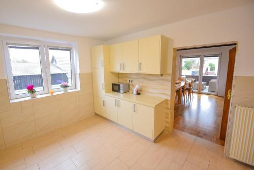 a kitchen with yellow cabinets and a dining room at Holiday Home Toplica Natura with natural thermal Bath in Cerklje ob Krki