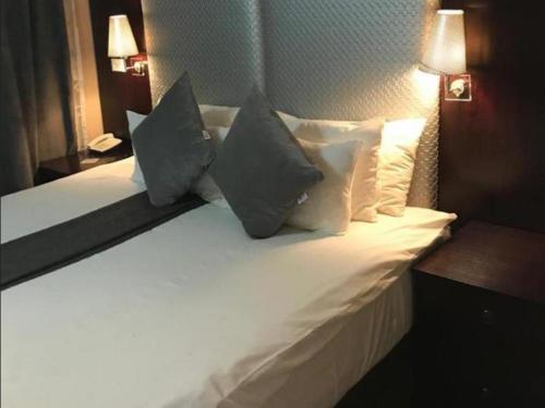 a large white bed with pillows in a hotel room at Le Chef BnB in Mthatha