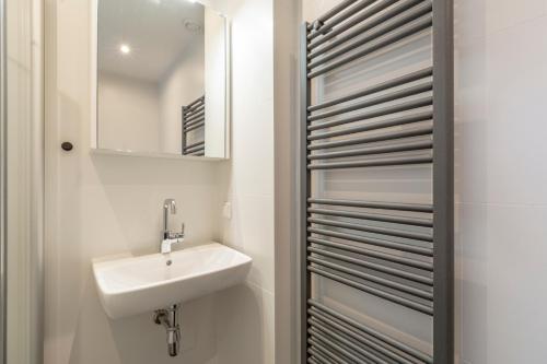 La salle de bains est pourvue d'un lavabo et d'un miroir. dans l'établissement Abbestederweg 24A Callantsoog, à Callantsoog