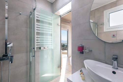 y baño con ducha, lavabo y espejo. en Villa Panorama en La Canea