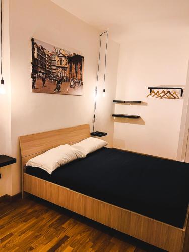 1 dormitorio con 1 cama y una pintura en la pared en Terno su Napoli Apartments, en Nápoles
