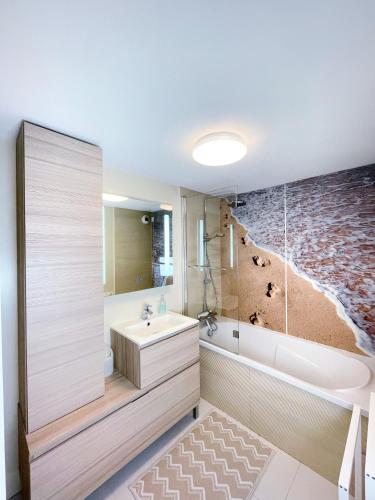 une salle de bain avec une baignoire, un lavabo et une douche dans l'établissement Duplex Loft with Terrace, Superb view of Port Guillaume, 7 minutes from the beach, à Dives-sur-Mer