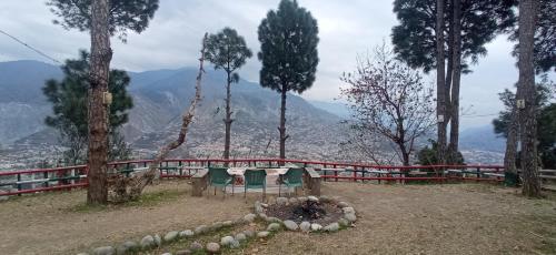 a table and chairs sitting on top of a hill at Eagle Nest Cottage Muzaffarabad by LMC in Muzaffarabad