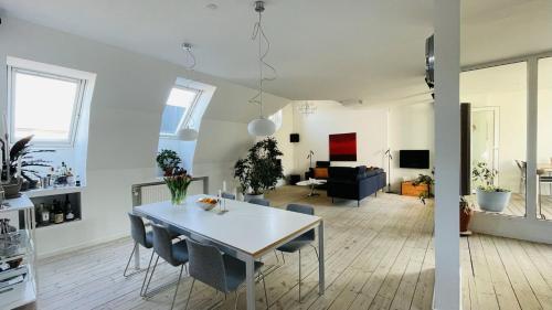 uma cozinha e sala de estar com mesa e cadeiras em ApartmentInCopenhagen Apartment 158 em Copenhague