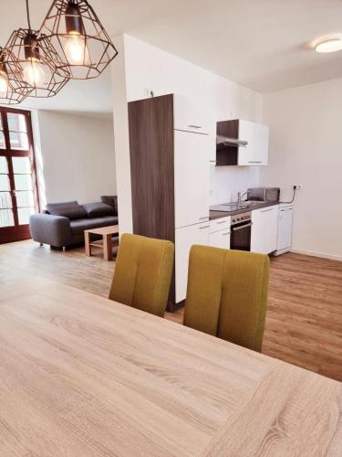 a kitchen and a living room with a table and chairs at Ferienwohnung Rio in Schneeberg