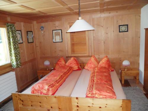 Un dormitorio con una cama con almohadas rojas. en Ferienwohnung Haus Bord, en Sankt Antönien