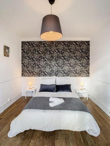 ein Schlafzimmer mit einem großen weißen Bett mit zwei Tischen in der Unterkunft Grand appart Chic centre ville 4 pers wifi in Pontoise