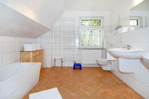 a bathroom with a tub sink and a toilet at Ferienhaus Nordseezauber in Esens