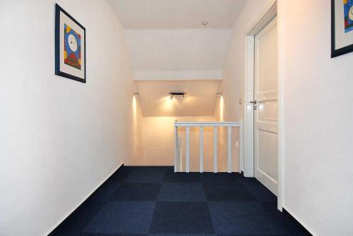 a hallway with white walls and a checkered floor at Ferienhaus Nordseezauber in Esens