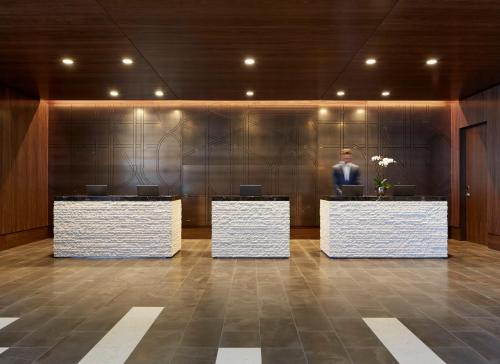 a man is standing behind two desks in a lobby at Loews Chicago Hotel in Chicago