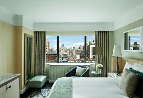 a hotel room with a bed and a large window at Loews Regency New York Hotel in New York