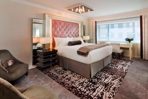a bedroom with a bed and a desk and a chair at Loews Regency New York Hotel in New York