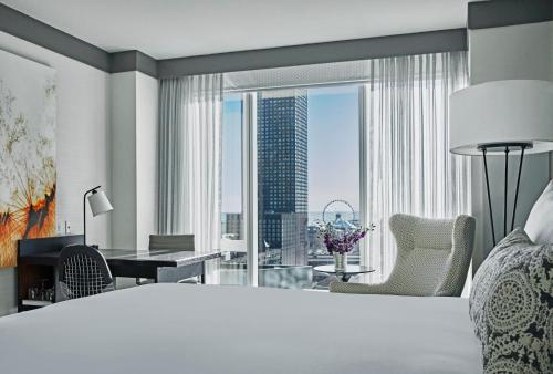 a bedroom with a large bed and a desk and a large window at Loews Chicago Hotel in Chicago