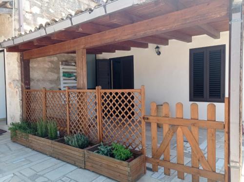 una valla de madera en un patio con una puerta de madera en La Casetta en Santa Croce Camerina