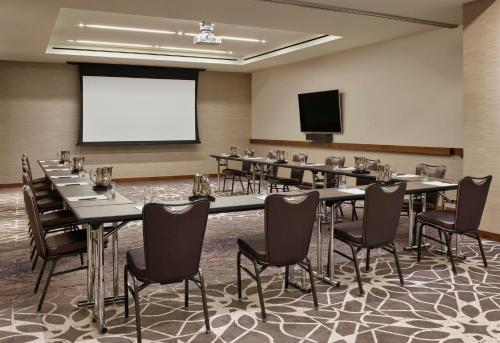 a conference room with tables and chairs and a screen at Loews Chicago Hotel in Chicago