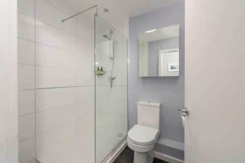 a bathroom with a toilet and a glass shower at Blue Yonder, Praa Sands in Praa Sands