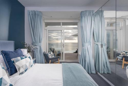 a bedroom with a bed with blue drapes at Blue Yonder, Praa Sands in Praa Sands