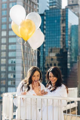 two women holding glasses of wine and balloons at Loews Regency New York Hotel in New York