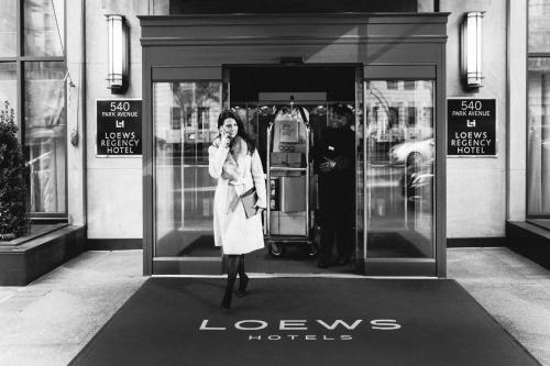 a woman talking on a cell phone in front of a store at Loews Regency New York Hotel in New York