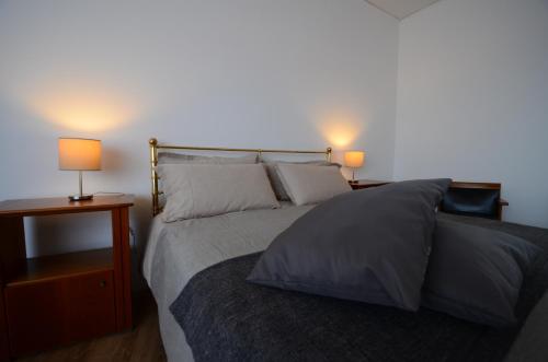 a bedroom with a bed with two lamps on two tables at B&B La Grola in San Martino Buon Albergo