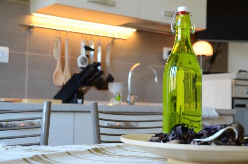 a green bottle sitting on a plate on a table at B&B La Grola in San Martino Buon Albergo