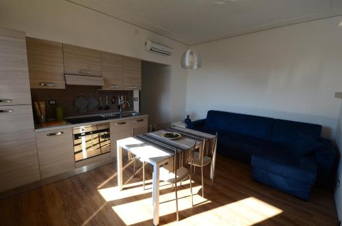 a small kitchen with a table and a blue couch at B&B La Grola in San Martino Buon Albergo