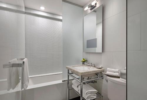 a white bathroom with a sink and a toilet at Loews Regency New York Hotel in New York