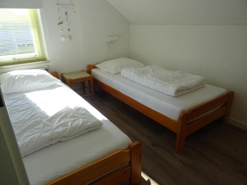 a room with two beds and a window at Kustverhuur, Vakantiepark Fort Soleil 23 in Breskens