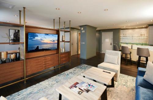 a living room with a tv and a table at The Lofton Hotel Minneapolis, Tapestry Collection by Hilton in Minneapolis