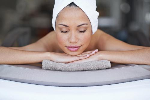 a woman with a towel on her head laying on a yoga mat at Loews Coral Gables Hotel in Miami