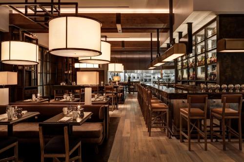 ein Restaurant mit Tischen, St&uuml;hlen und Kronleuchtern in der Unterkunft Loews Philadelphia Hotel in Philadelphia