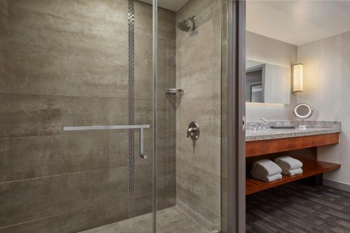 a bathroom with a shower and a sink at Loews Hollywood Hotel in Los Angeles