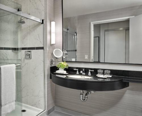 a bathroom with a sink and a mirror and a shower at Loews Philadelphia Hotel in Philadelphia