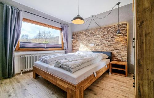 a bedroom with a bed and a brick wall at Pet Friendly Apartment in Wieda