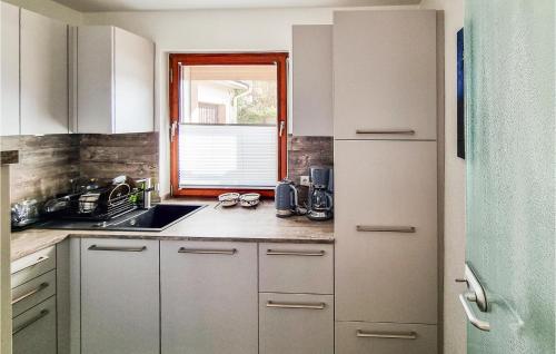 a kitchen with white cabinets and a sink and a window at Pet Friendly Apartment in Wieda
