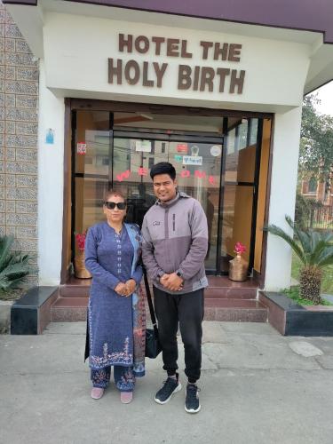 a man and a woman standing in front of a hotel at Hotel The Holy Birth in Lumbini